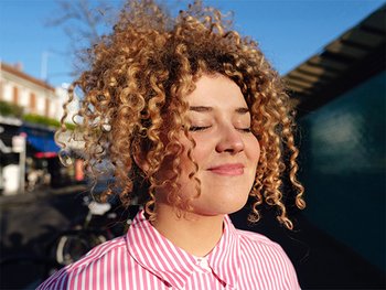 Close-up of a person with conditioned curly hair.