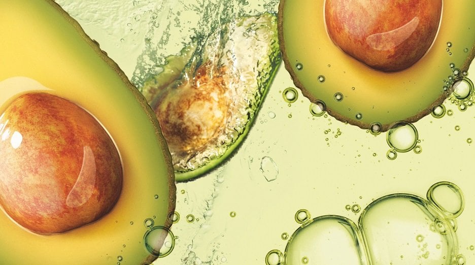 Avocado oil's nourishing properties benefit skin and hair, as seen with these avocado slices immersed in the oil.