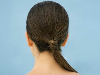 The back of a head with long, brown hair demonstrates a wrapped ponytail style.