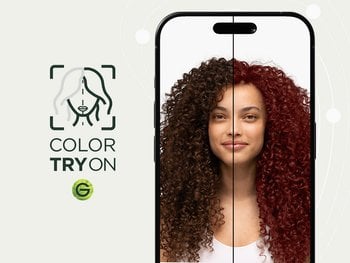 A woman with type 4 curly hair in a natural dark brown shade using Garnier's Virtual Try-On tool to virtually try on an auburn red hair shade.