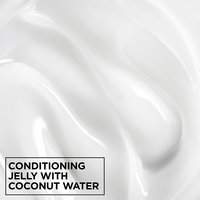 Macro texture shot of smooth, white Garnier Fructis Curl Shine Conditioning Jelly infused with coconut water for intense hair hydration.