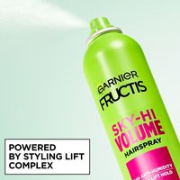 A close-up action shot of the hairspray being used. Text at the bottom left reads "POWERED BY STYLING LIFT COMPLEX".