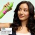A woman holding the can near her head with text at the bottom reading "TIPS: Lift hair & spray towards roots".