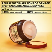 Key benefits of Garnier Whole Blends Honey Treasures hair mask: open jar showcasing creamy texture and clinical claims of up to +49% more hair strength and +83% more moisture for damaged hair.