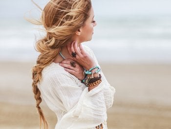 Shot of a young woman with long, blonde braided hair at the beach.