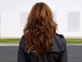 The back of a person's head with medium-length, golden-brown hair, representing warmer tones like golds, coppers, reds, and auburns.