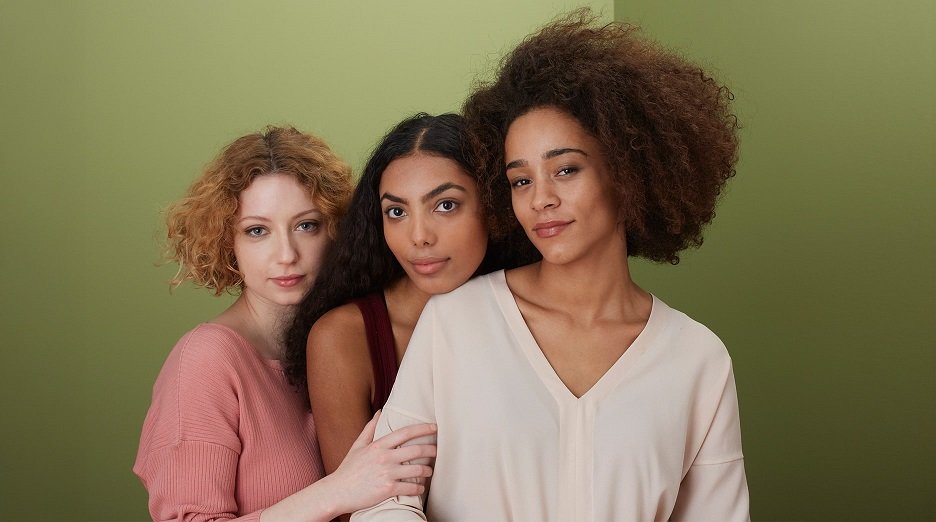 Three women with different colored hair and textures.