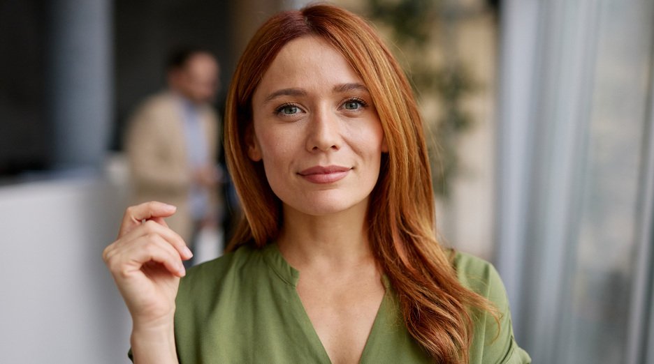 Woman with auburn red hair smiling.