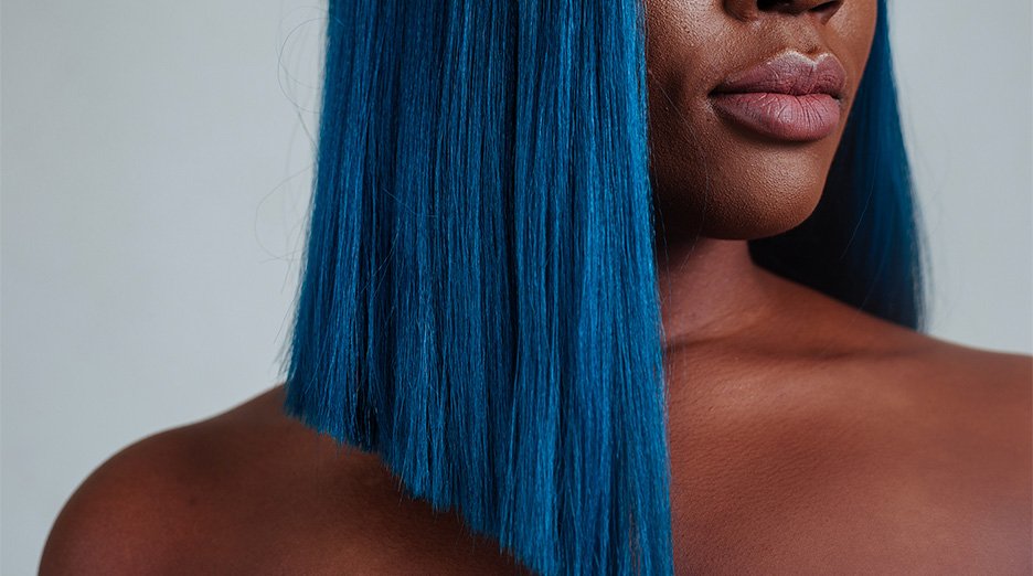Dark skinned woman with short blue hair