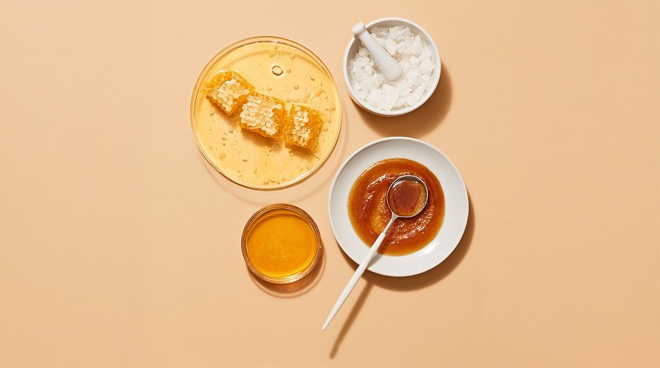 Bowls of honey, coconut oil, and shea butter, common hair mask ingredients.