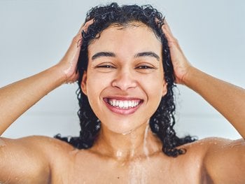 A woman conditions her hair in the shower.