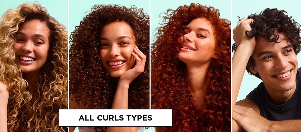 Four smiling models with blonde, brunette, red, and dark curly hairstyles ranging from loose waves to tight coils, labeled "All Curls Types" to showcase diverse curl patterns.