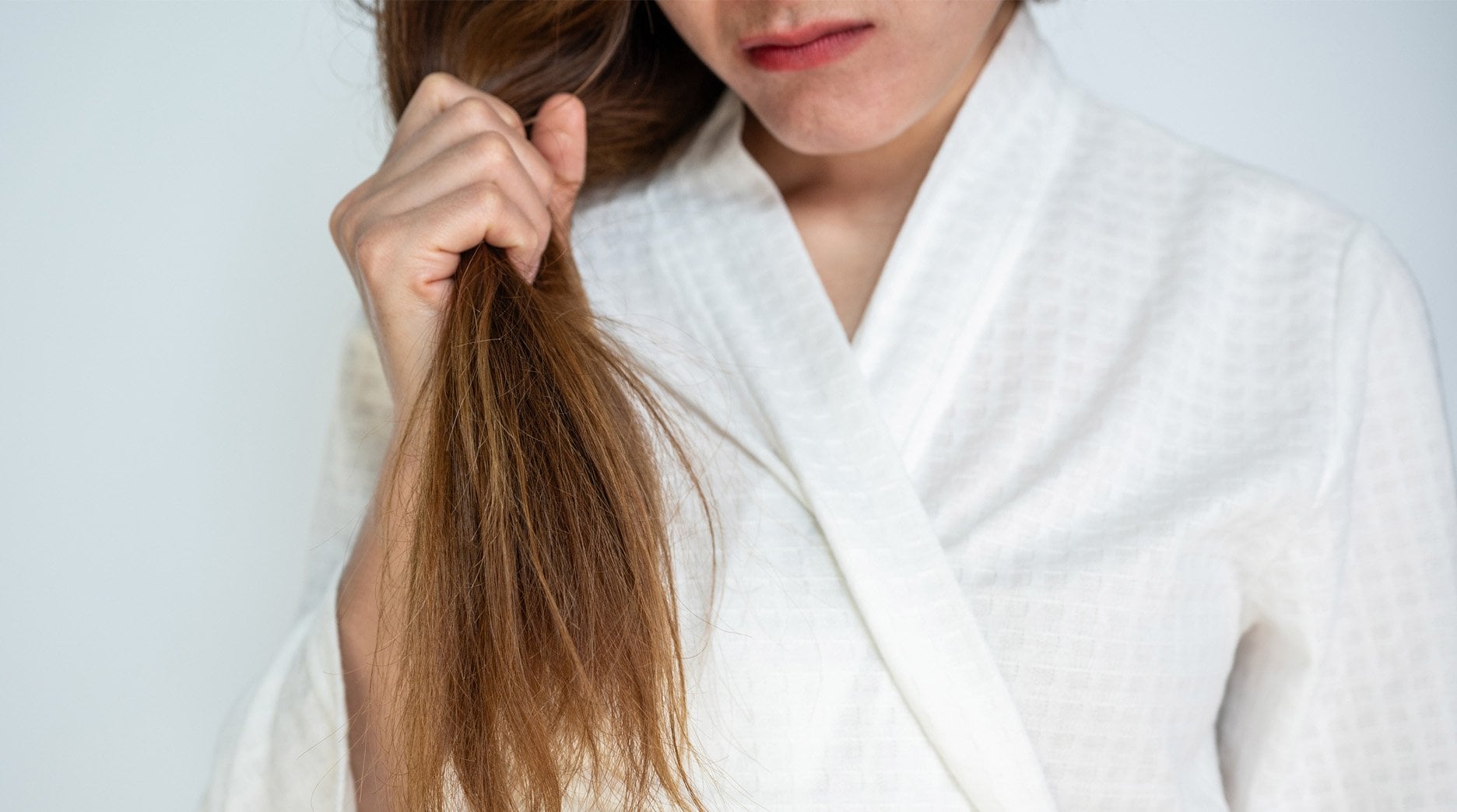 Woman holding strand of split ends