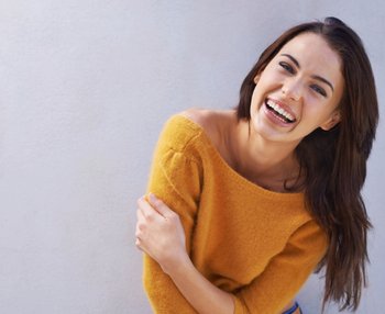Brunette model with long hair smiling at the camera.