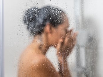 A blurry image of a person in a steamy shower.
