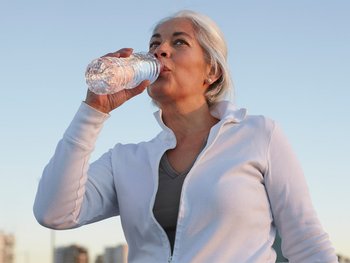 A person drinking water from a bottle.
