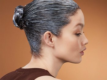 Woman with her hair in a slicked-back bun, prepped for styling.