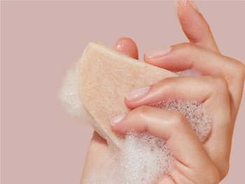 Foamy hand holding a shampoo bar.