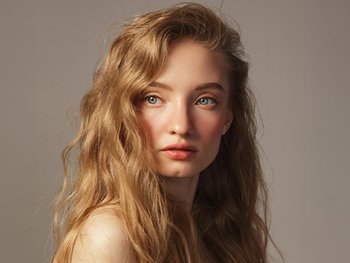 Woman with shoulder-length, wavy blonde hair.