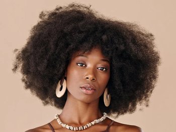 Woman with tightly coiled, voluminous hair.
