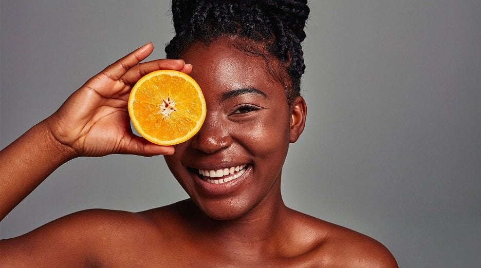 Benefits of Vitamin C for hair scalp care woman holding slice orange health skin hair - Garnier