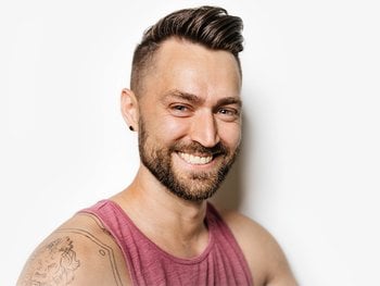 Portrait of man with tank top, portraying “the quaff” hairstyle.