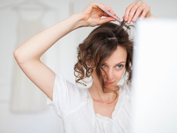 Brunette woman who is pinning her hair up.