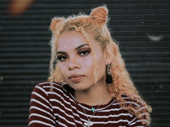 Curly hair half up half down bun for holiday season - Garnier