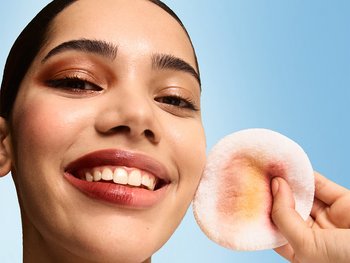 Close-up of a young woman using a reusable eco-pad applying Garnier Micellar Peeling Water for a daily glycolic acid glow.