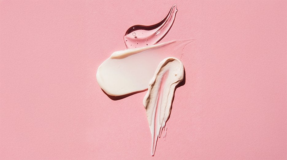 Three smears of products are displayed on a pink background.