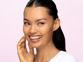 Woman smiling with deeply hydrated, plump skin after using a dry skin hydration routine featuring Garnier Micellar Water