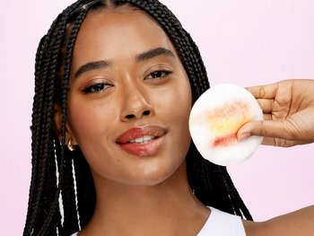 Person gently applying Garnier Water Rose Micellar Cleansing Water with a reusable eco-pad to prep for a hydrating moisturizer for dry skin.