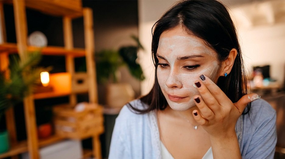 Woman applying face mask