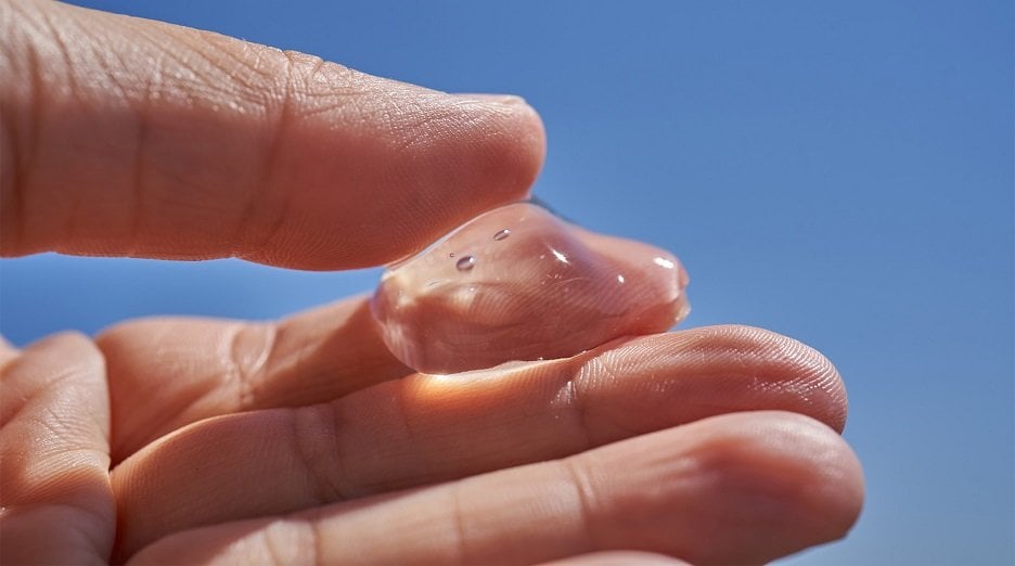 Hand holding a clear gel-like skincare product.