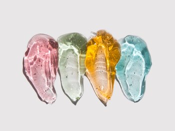 Four different colored skincare products.