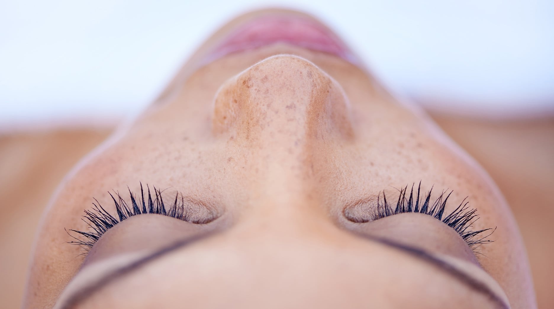 Young woman with clear hydrated skin, in a deeply relaxed state of mind before receiving a facial