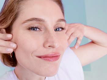 A woman gently touches her face, which appears clean and hydrated, conveying the benefits of micellar water.