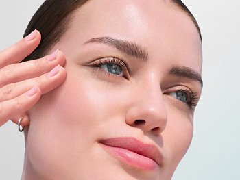 Close-up of a person applying skincare product.
