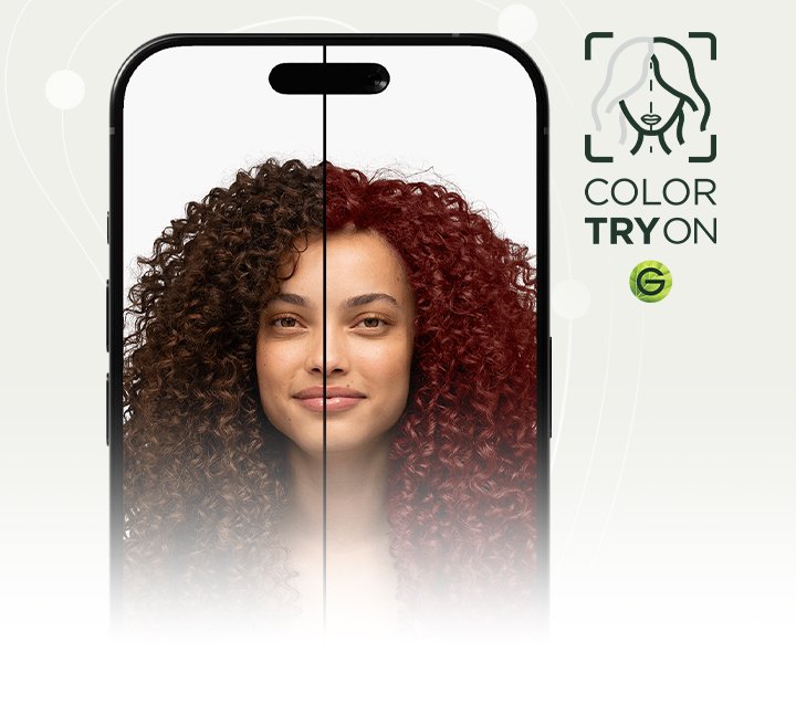 A woman with type 4 curly hair in a natural dark brown shade using Garnier's Virtual Try-On tool to virtually try on an auburn red hair shade.