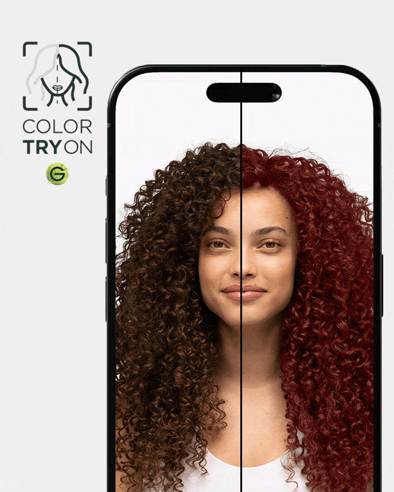 A woman with type 4 curly hair in a natural dark brown shade using Garnier's Virtual Try-On tool to virtually try on an auburn red hair shade.