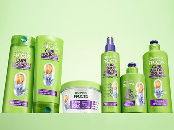 A collection of Garnier Fructis Curl Nourish products, including shampoo, conditioner, Flexi-Hold Curls, Curl Knot Melter, and Curl Air Dry Cream.