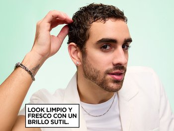 Garnier Fructis Style model running his fingers through damp, defined dark curls defined and styled with Pure Clean Styling Gel and Finishing Paste, while wearing a white blazer and silver chain necklace, next to on-image text reading "CLEAN, FRESH LOOK WITH SOFT-SHINE FINISH," set against a mint green background.