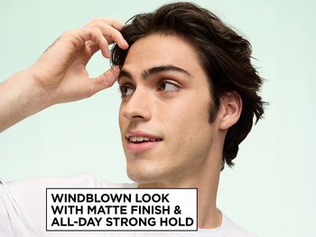Garnier Fructis Style model showcasing a windblown look achieved with Surfer Hair Power Putty, next to on-image text reading "WINDBLOWN LOOK WITH MATTE FINISH & ALL-DAY STRONG HOLD," set against a mint green background.