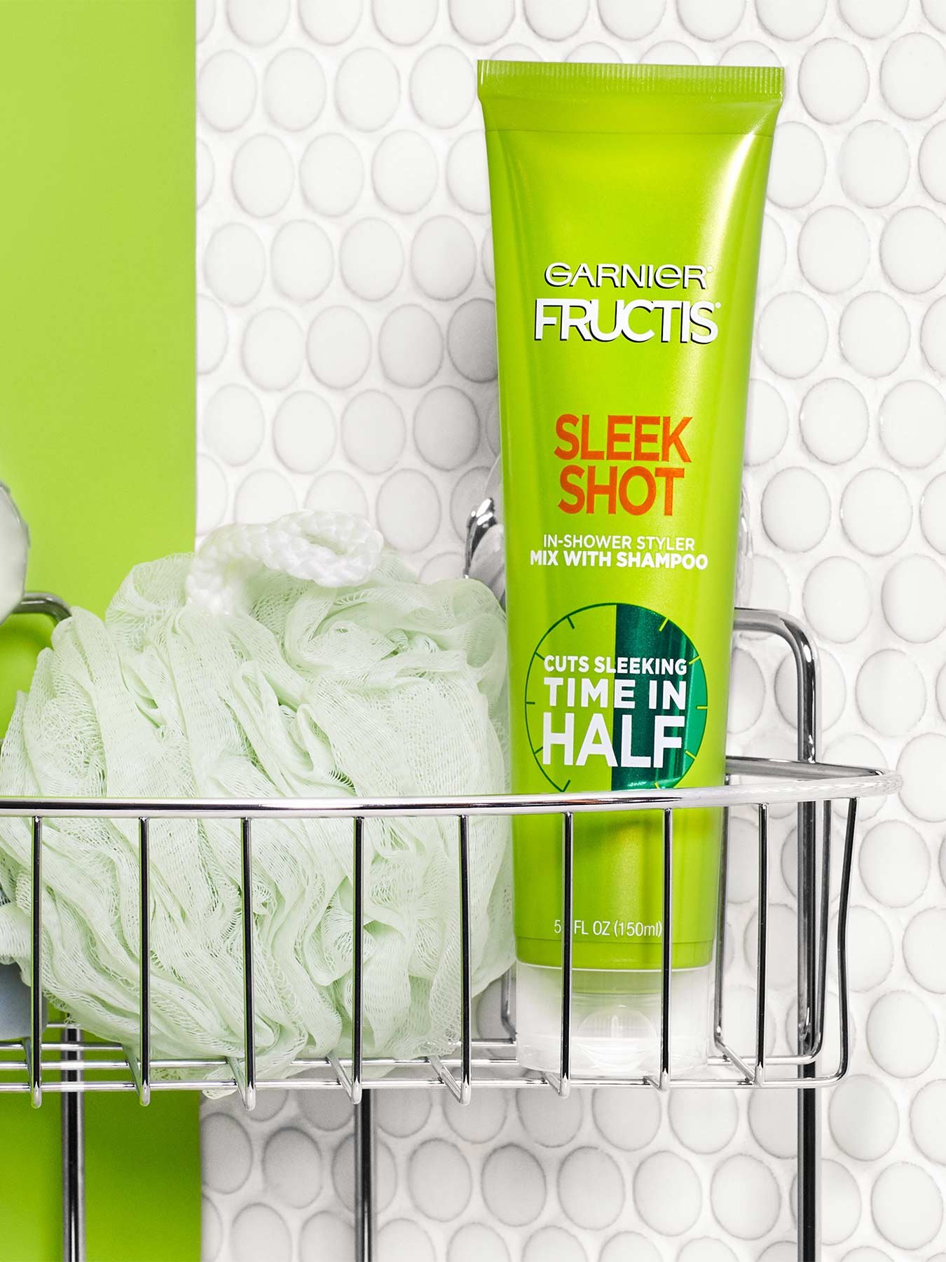 Sleek Shot In-Shower Styler in a shower rack with green-grey soap and a light green bath poof in a green and dotted-white bathroom.