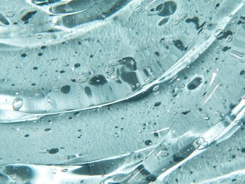 Texture of gel cream liquid Glycolic Acid gel on blue background