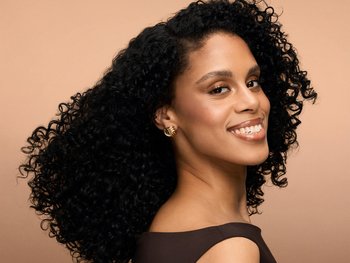 Female model with curly black hair smiling