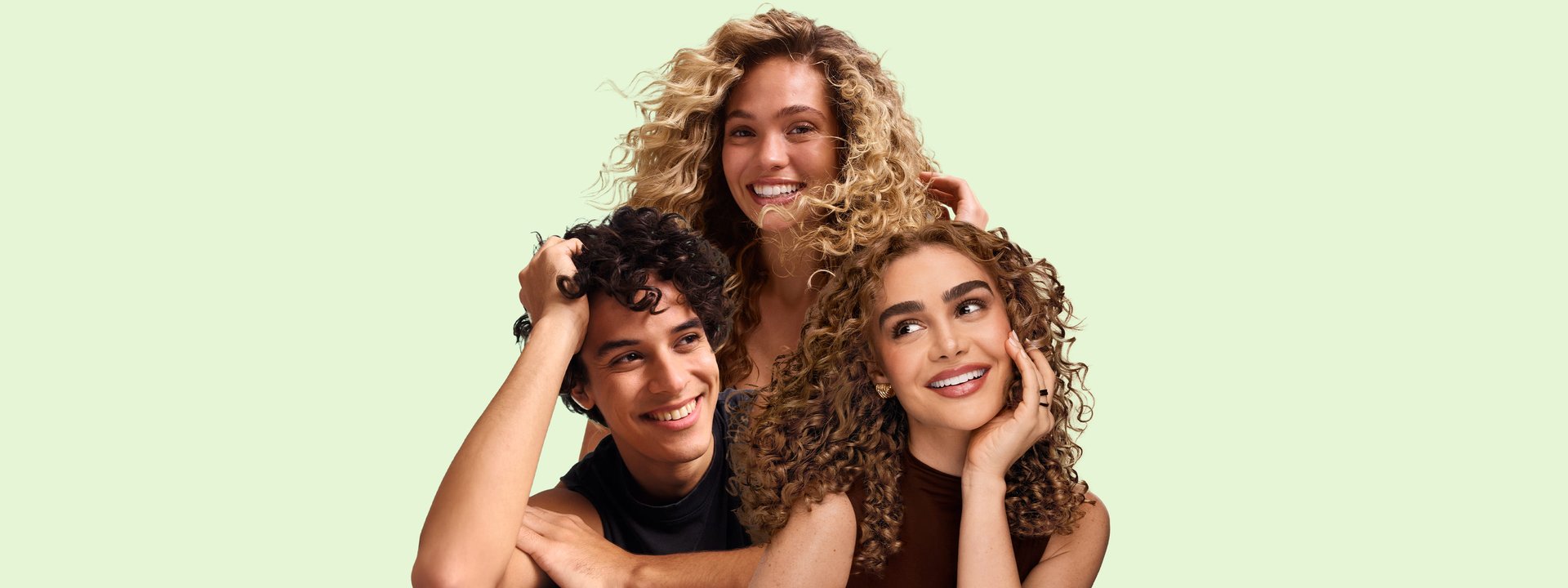 2 female models and 1 male model with wavy and curly hair against a pale green background