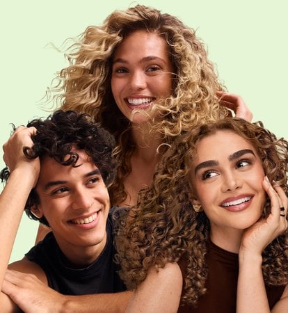 2 female models and 1 male model with wavy and curly hair against a pale green background
