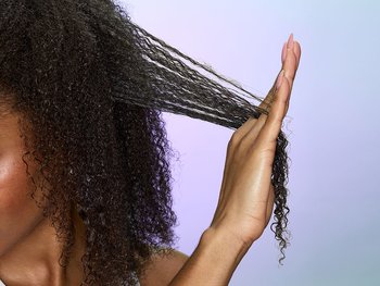 Close-up of hands applying hair gel for textured and tousled hairstyle.