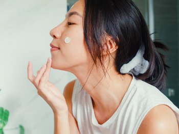 Model applying cream to face